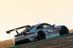 Porsche coming over a curve.