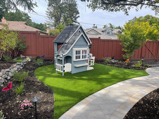 Backyard synthetic turf with a kids play structure.