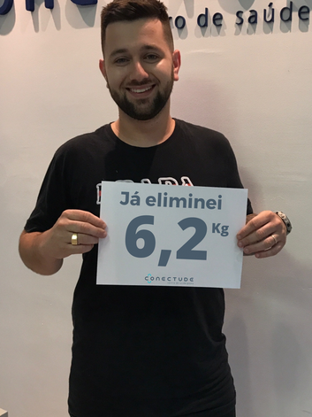 Jardel segurando sua placa com o resultado de finalizar o programa de emagrecimento integrativo.