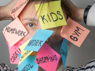A photo of a woman whose face is covered in sticky notes with different tasks written on them, representing the link between mental load and burnout for moms.