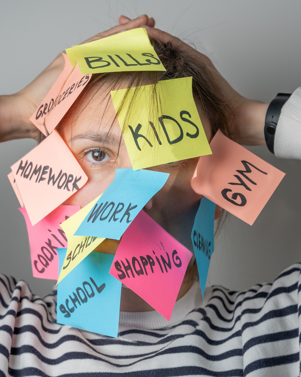 A photo of a woman whose face is covered in sticky notes with different tasks written on them, representing the link between mental load and burnout for moms.