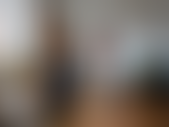 A photo of a couple cleaning and organizing the house together, each responsible for a different chore, portraying how involving other family members makes decluttering more manageable for moms.