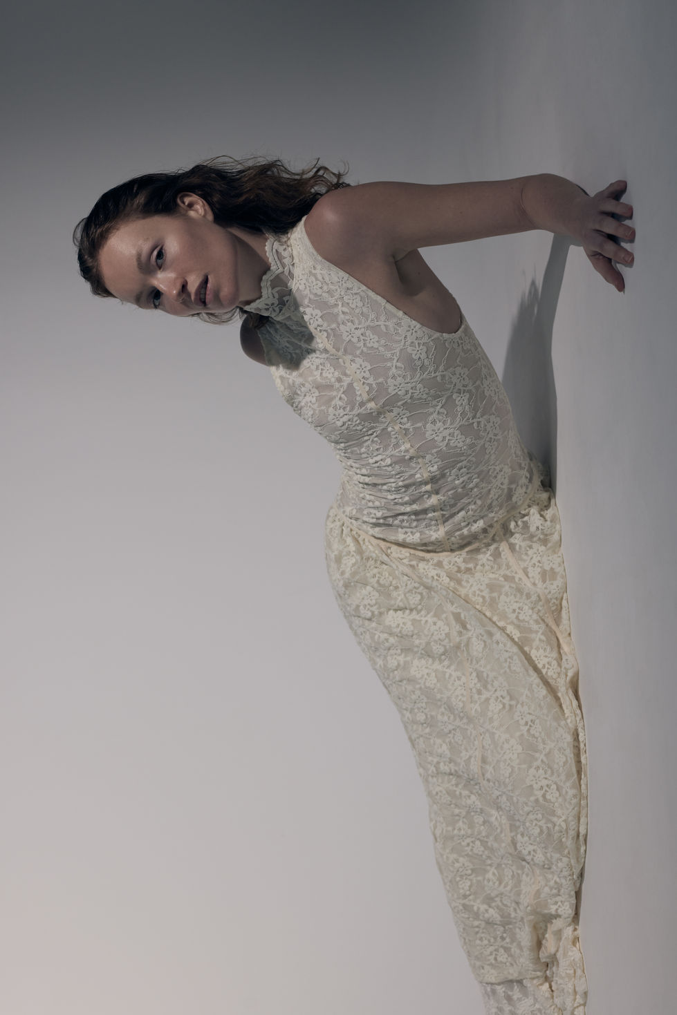 Portrait mouvement bras, robe dentelle blanche, éditorial studio ombre portée — styliste Laurane Croguennec