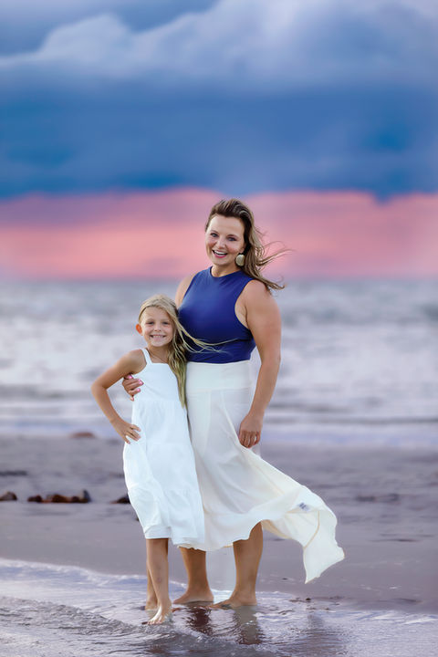 Mom and daughter enjoying a peaceful moment together on the beach, capturing family love in a natural setting.