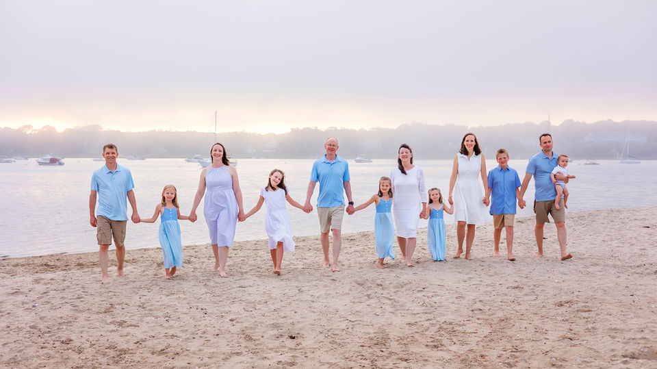 Extended family walking together on the beach, enjoying the moment with the ocean in the background. cape cod photographers