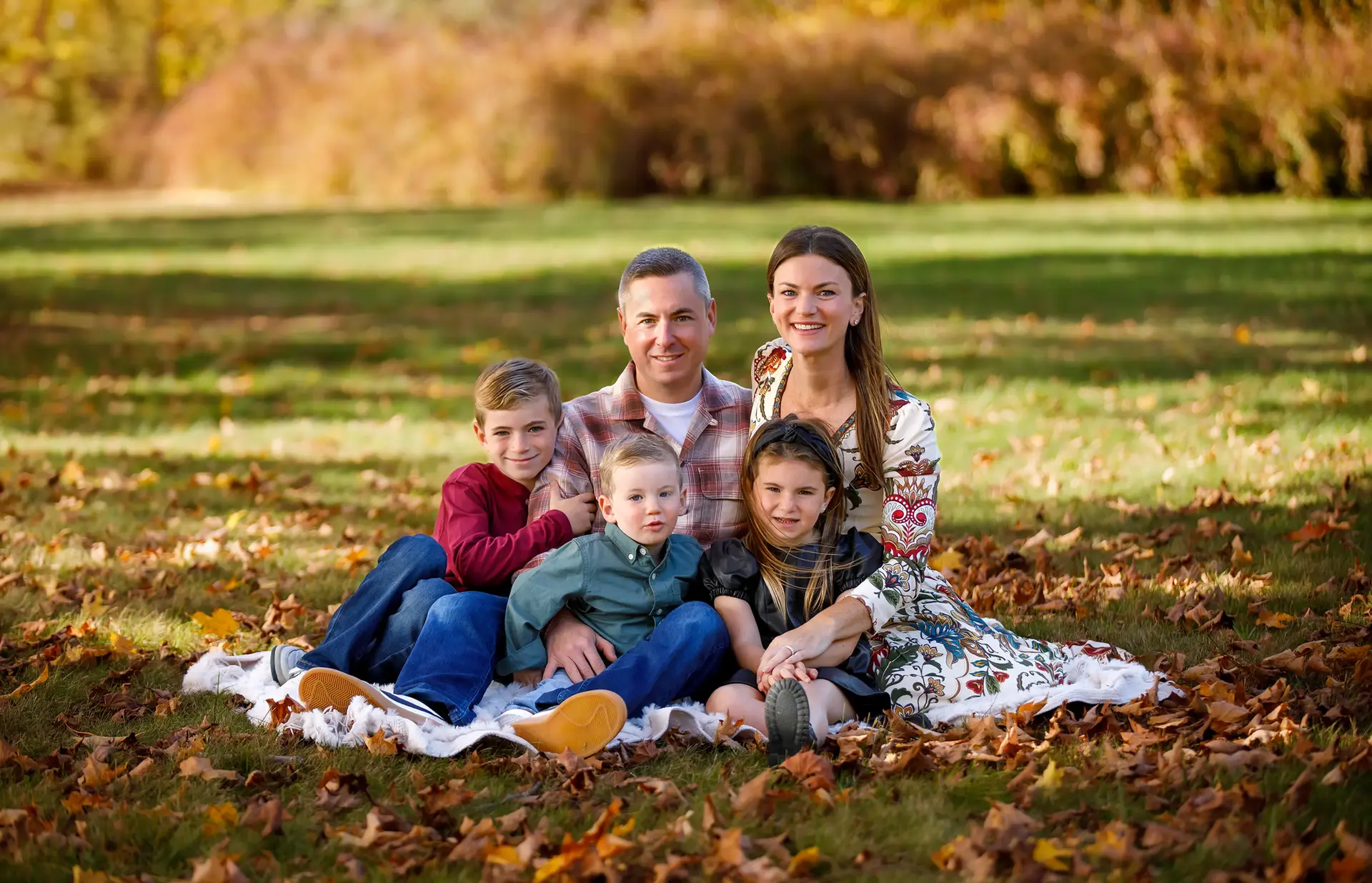 Fall family photograph of a family of five. Warm inviting colors.