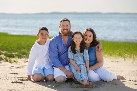 Small family smiling and playing together on the beach, captured in a joyful moment of love and connection. cape cod photographers