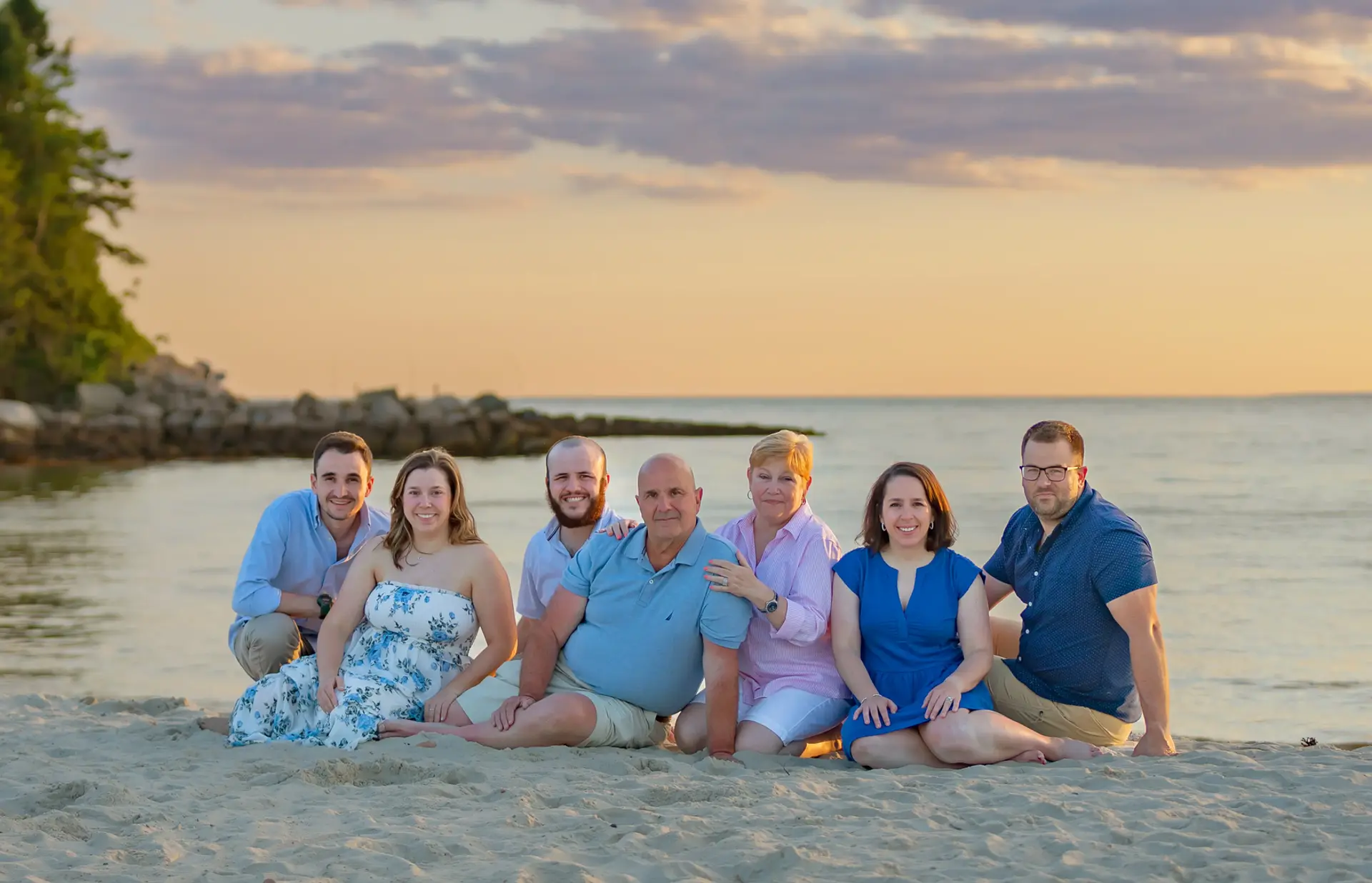 Family posed for a portrait during sunset at a beach.