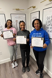 Smiling doula holding certification from Empowered Black Doula
