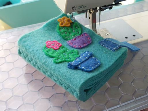 Green felt needle book sitting on a sewing machine