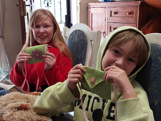 two girls bragging with their sewing projects during sewing lessons