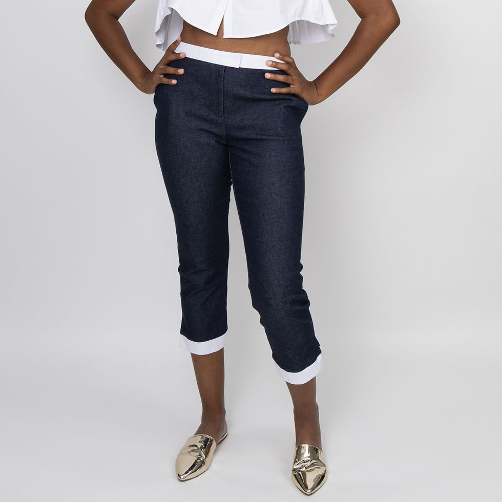 Woman in contemporary dark capri pants, white top, gold flats