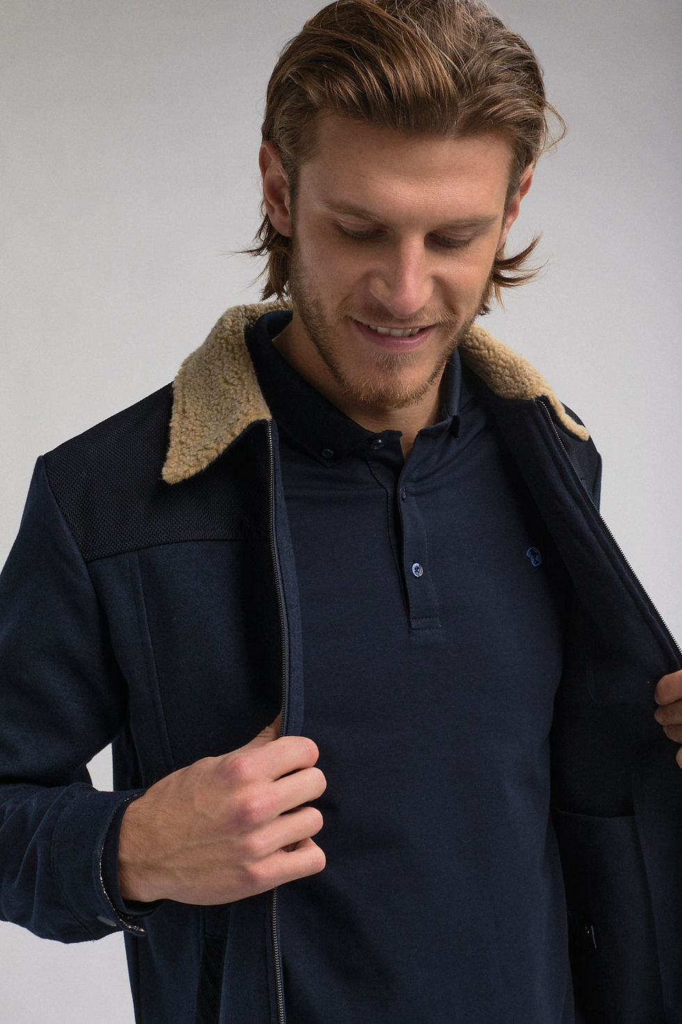 image couleur format portrait. Photo mode masculine prêt-à porter de la marque " Benson & Cherry ". Homme souriant. Photo homme portrait et buste. L'homme porte une veste bleu marine à col beige.