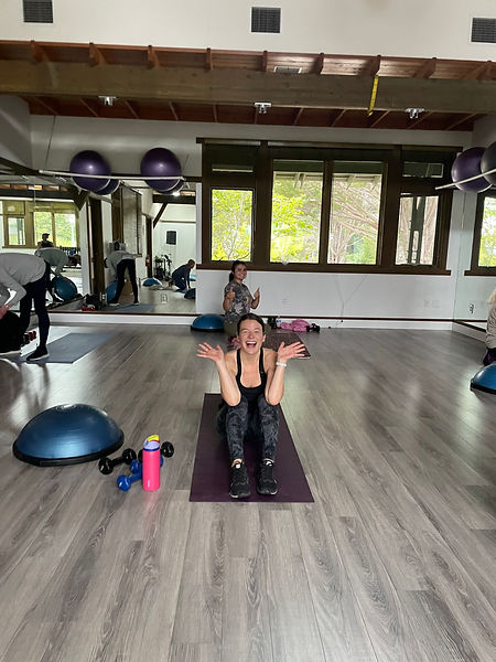 strength training class at gym — coached group workout with barbells and dumbbells