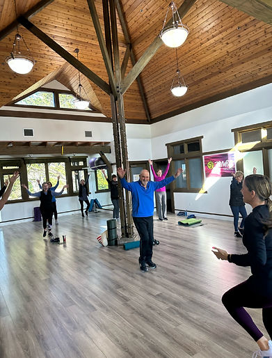 strength training class at gym — coached group workout with barbells and dumbbells