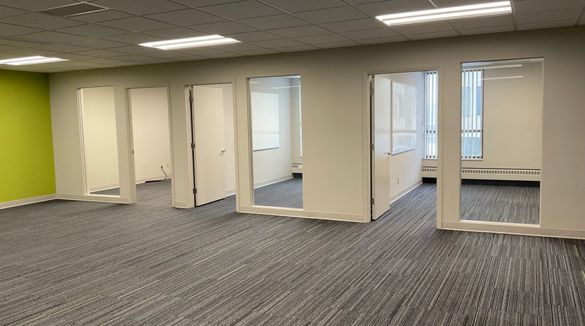Wide office space in PDC Building, Ohio with beige and green walls