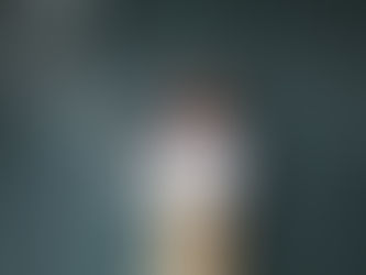 Girl sood in front of a blackboard smiling, lets of words and symbols are coming from her phone.