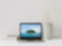 Laptop on a desk with a tropical island on the screen