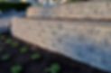 A beautiful view of a gray colored 2 tier retaining wall built with concrete blocks in ear