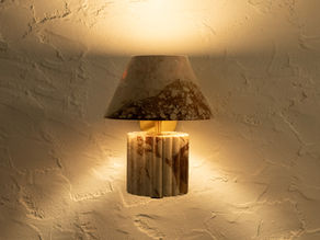 Lit marble wall sconce glowing against a textured plaster wall