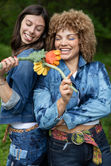 two women wearing denim jackets that are dyed , bleached, and jeans with patches