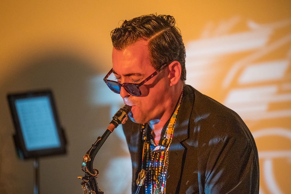 Alex Sax performing live on saxophone,