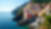Eye-level view of colorful houses stacked on cliffs overlooking the Mediterranean Sea in Cinque Terre