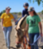 A young girl riding her horse Zeva at SPURS with her teacher as her sidewalker