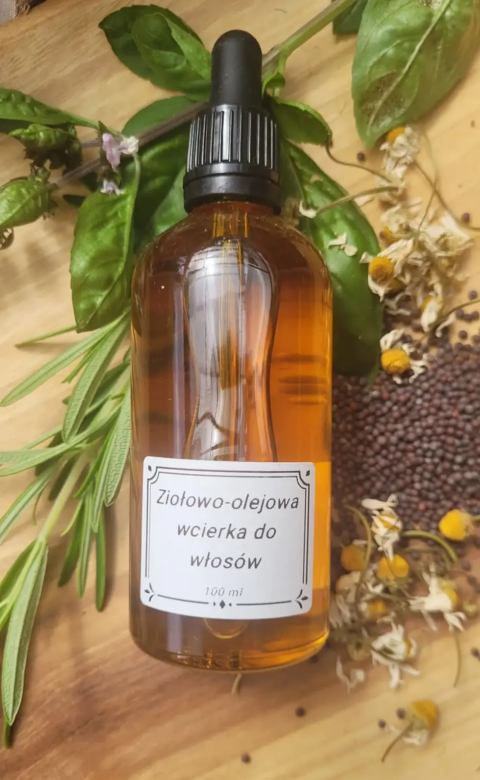 buteleczka rozmarynowej wcierki do włosów na tle suszonych kwiatów