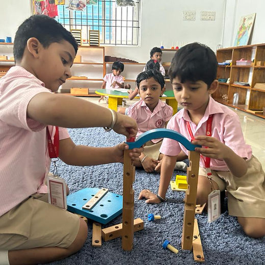 Two children building with wooden Montessori materials