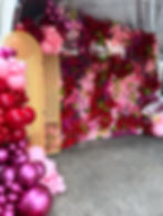 Pink and red roses mixed with magenta florals and greenery in an organic shape and pattern