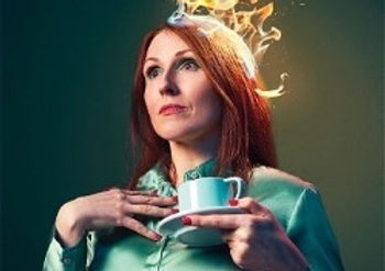 Suzy Cruthers in a green satin shirt with a cup of tea stares into the distance. Her hair is on fire.