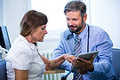 male-doctor-discussing-with-patient-digital-tablet.jpg