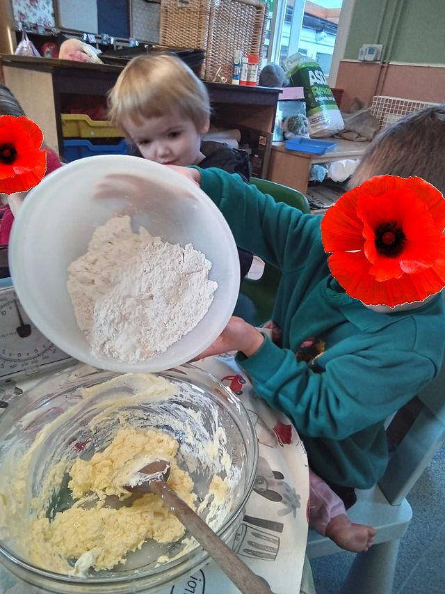 a young boy wearing Fun Box Day Nursery uniform is pouring flour from a plastic bowl to another bowl containing butter and a spoon