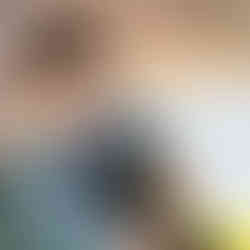 a little boy is holding a pair of scissors cutting yellow paper stripes off of a larger white circular paper