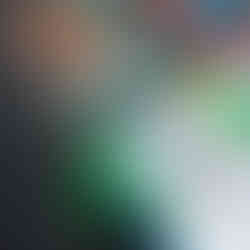 a little boy is letting go of a small yellow truck, that was dipped in paint, the truck is running down on a small slide covered with paper