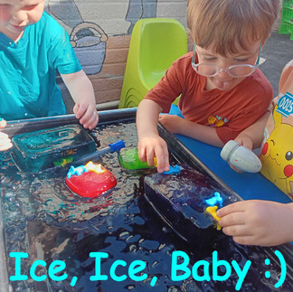 a group of little children are exploring ice and water over a black sensory tray