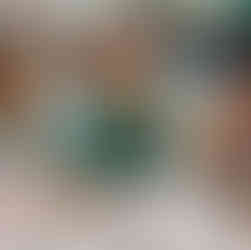 a little girl wearing Fun Box Day Nursery uniform is looking at the camera as she is reaching for a sandwich