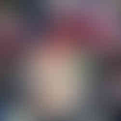 a group of young children wearing tabards are making prints with various vegetables on a large brown paper in a builders tray