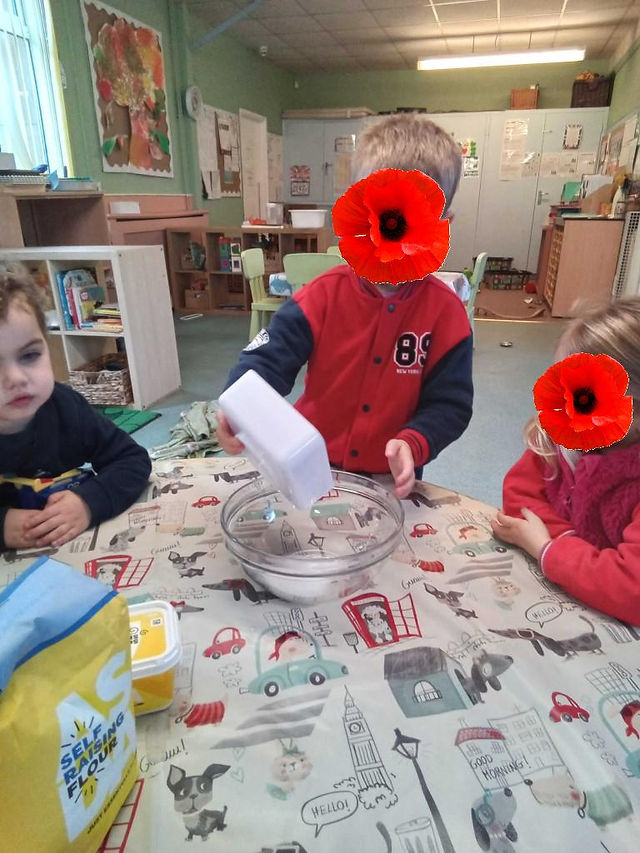 three young chilren are taking part in a cooking activity at Fun box Day Nursery in Totton, the one in the middle is pouring flour into a glass bowl