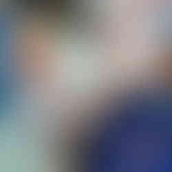 two little boys are exploring some toy fish placed in a builders tray with blue paper in it