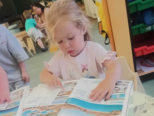 a child is looking at travel brochures at Fun Box Day Nursery in Totton