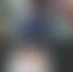 a little boy is looking at the camera while he is trying to break a block of ice containing natural objects, like a mini pumpkin