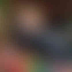 a blonde haired little boy is holding a colourful xylophone and smiling to the camera