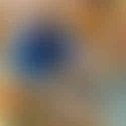 a young child wearing a blue jumper is holding a wooden spoon trying to scoop a toy food out from a metal pot in a nursery environment