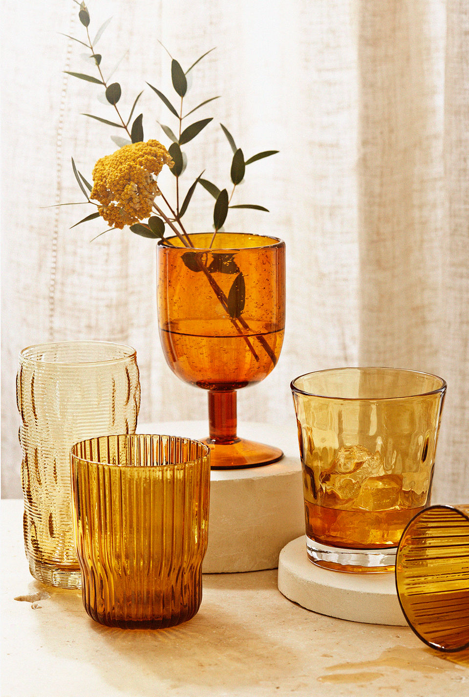 a cluster of smoke coloured glasses on a stone setting with a tan backdrop