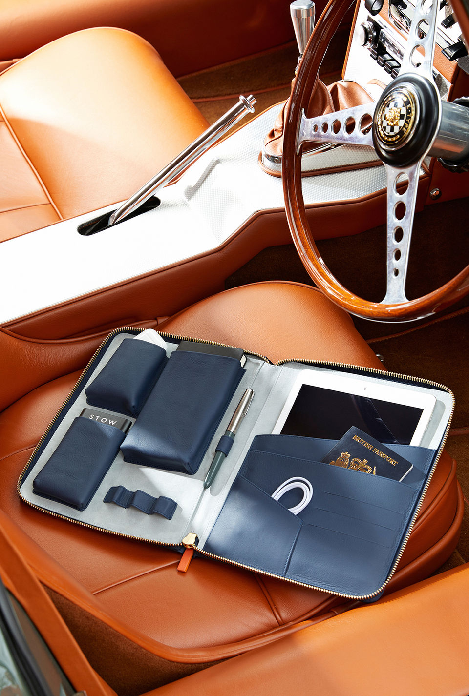 Leather folder with ipad inside on the front seat of a sportscar