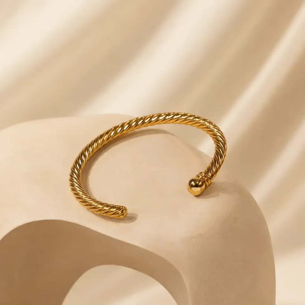 Bracelet doré torsadé LIKAM présenté sur fond beige élégant