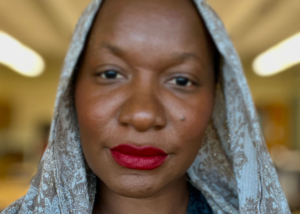 Black woman of medium to dark brown skin  wearing a scarf and a bold red lip. 