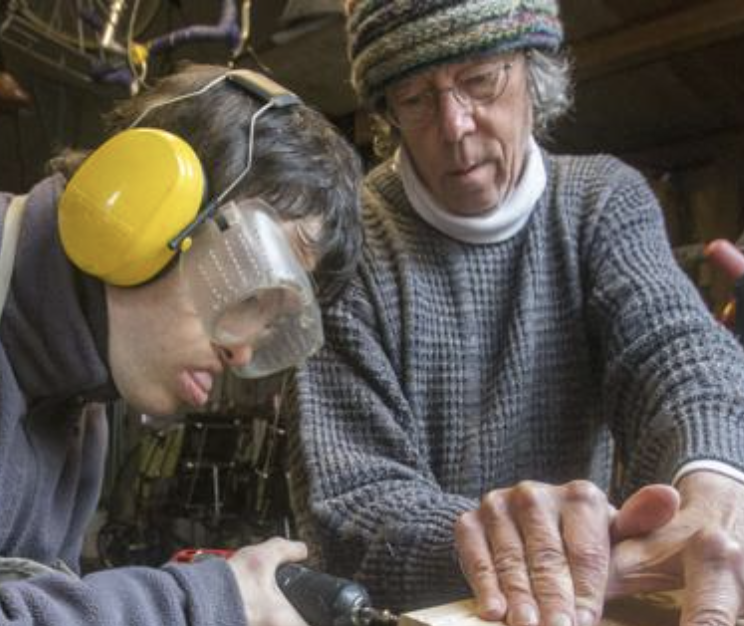 Image of Board Member Paul Anderman and his grandson working with tools. 